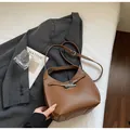 Detailed shot of caramel lychee grain leather bucket bag with silver buckle and shoulder strap - Brown