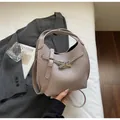 Macro detail of taupe lychee grain leather bucket bag with silver metal cross lock closure - Gray