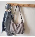 Détail du sac bandoulière gris demi-lune avec logo Midolee suspendu à un crochet - Gris Sans Pendentif