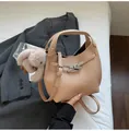 Close-up of beige leather bucket bag featuring silver twist-lock and cute rabbit charm - With Pendant / Khaki