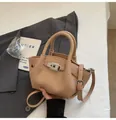 Detailaufnahme der beigen Beuteltasche aus genarbtem Leder mit silbernem Drehverschluss - Khaki