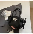 Detail der schwarzen Beuteltasche aus genarbtem Leder mit silbernem Schloss und Riemen - Schwarz