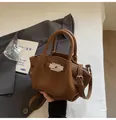 Nahaufnahme der braunen Handtasche aus Narbenleder mit Silberschnalle und Logo-Prägung - Braun