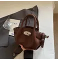 Detail der braunen Ledertasche mit Lychee-Maserung, Silberschnalle und runden Griffen - Braun