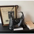 Detalle del bolso tote minimalista de cuero negro con correa ajustable y herrajes metálicos - Sin colgante / Negro