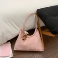Close-up of pink suede hobo bag with sparkling floral crystal patterns and plush charms - With Pendant / Pink