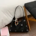 Detailed texture of black suede handbag featuring sparkling silver rhinestone floral patterns - With Pendant / Black