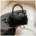 Close-up of black lychee grain leather handbag with dual metal zippers and round handles - Without Pendant / Black