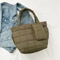 Detailed macro view of olive green quilted tote bag with matching zipper pouch accessory - Green
