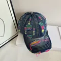 Dettaglio del cappellino in denim blu lavato con fori consumati e cuciture colorate - M (56-58cm) / Blu scuro