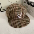 Close-up of vintage houndstooth flat cap with white letter H embroidery on wool fabric - M (56-58cm) / Houndstooth