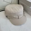 Dettaglio del berretto militare in tela beige con bottoni in metallo e trama del tessuto - M / Bianco Sporco