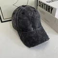 Detail einer verwaschenen Denim-Baseballkappe mit Vintage-Effekten und Fransenrand - M (56-58cm) / Schwarz
