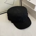 Dettaglio del cappello militare nero in tela con cinturino decorativo e fibbia in metallo - M / Nero