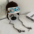 Detail of crochet pilot knit hat with goggles decor and long braided tassels - M / Coffee