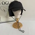 Detail of winter earflap cap with fleece texture and adjustable windproof strap - M (56-58cm) / Black