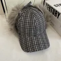 Detalle de gorra de invierno a cuadros con forro de piel sintética gris y lazo suave - M / Negro