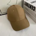 Detalle de gorra de béisbol caqui mostrando costuras, ojales y la visera curva - M / Camel