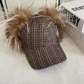 Detalle de gorro de aviador a cuadros marrones con pelo sintético en fondo blanco - M / Caqui