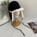 Nahaufnahme der schwarzen Winter-Fliegermütze mit weißem Plüschfutter und Bindebändern - M (56-58cm) / Schwarz