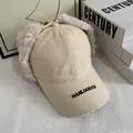 Detail of beige aviator hat with faux rabbit fur ear flaps and black letter embroidery - M (56-58cm) / White