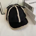 Detailansicht der Wintermütze aus schwarzem Wildleder mit beigem Lammfell-Innenfutter - M (56-58cm) / Schwarz