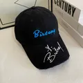 Close-up of blue Birteny embroidery and distressed brim on a black cotton baseball cap - M / Black