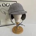 Detailed view of grey plaid wool trapper hat with ear flaps on a wooden stand - M(56-58cm) / Gray