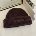 Detalle de la textura del gorro de punto marrón oscuro con parches de estrellas de cuero - M / Café