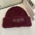 Primer plano del gorro de punto granate con tres parches de estrellas y textura gruesa - M / Burdeos
