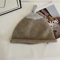 Detailed close-up of a two-tone knit beanie with a stylish top knot design - M (56-58cm) / Khaki