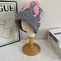 Dettaglio di un berretto in maglia grossa grigio scuro con motivo a cavalluccio marino rosa - M(56-58cm) / Grigio chiaro