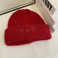 Primer plano del gorro de punto rojo oscuro con tres estrellas en el borde doblado - M / Rojo