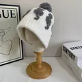Dettaglio di un cappello di maglia beige con pompon grigio e bordo largo a coste - M(56-58cm) / Bianco