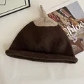 Detail of soft knit texture on two-tone winter beanie with stylish top knot design - M (56-58cm) / Coffee