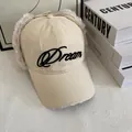 Détail d'une casquette en toile beige avec protège-oreilles en peluche et broderie Dream - M(56-58cm) / Blanc