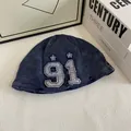 Dettaglio del cappello docker in velluto blu scuro con ricamo vintage del numero 91 - M / Blu