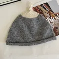 Detail of two-tone knit beanie featuring thick grey and cream texture and top knot - M (56-58cm) / Gray