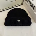 Primo piano del berretto in maglia a coste nere con ricamo di cucciolo bianco e trama spessa - Nero