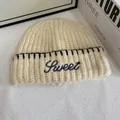 Close-up of beige knit beanie with black SWEET embroidery and thick ribbed cuff detail - M(56-58cm) / Off White