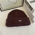 Close-up of dark brown distressed knit beanie featuring white animal embroidery detail - Coffee