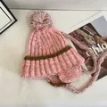Detail of pink marled knit beanie with fluffy pom-pom and braided earflaps - M (56-58cm) / Pink