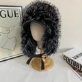 Detail view of mixed black and white faux fur trapper hat with leather brim and ribbon - Black