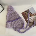 Detailed knit texture of light purple pom-pom hat with earflaps and braided straps - M (56-58cm) / Purple