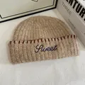 Detail of beige knit beanie showing blue Sweet embroidery and red contrast stitching - M(56-58cm) / Khaki