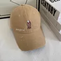 Detailed close-up of khaki baseball cap featuring bear embroidery and distressed brim - M / Khaki