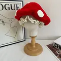 Close-up of handmade crochet mushroom hat with white polka dots and ruffled hem details - M (56-58cm) / Red