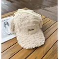 Détail du bonnet à rabats en polaire crème avec étiquette Freedom et nœud doux - M (56-58cm) / Blanc Cassé