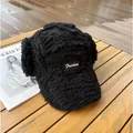 Détail d'une chapka noire en laine d'agneau avec broderie Freedom sur bois sombre - M (56-58cm) / Noir
