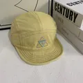 Detail der Kontraststickerei und lila Nähte an einer gelben 5-Panel Camper-Baseballkappe - M (56-58cm) / Gelb